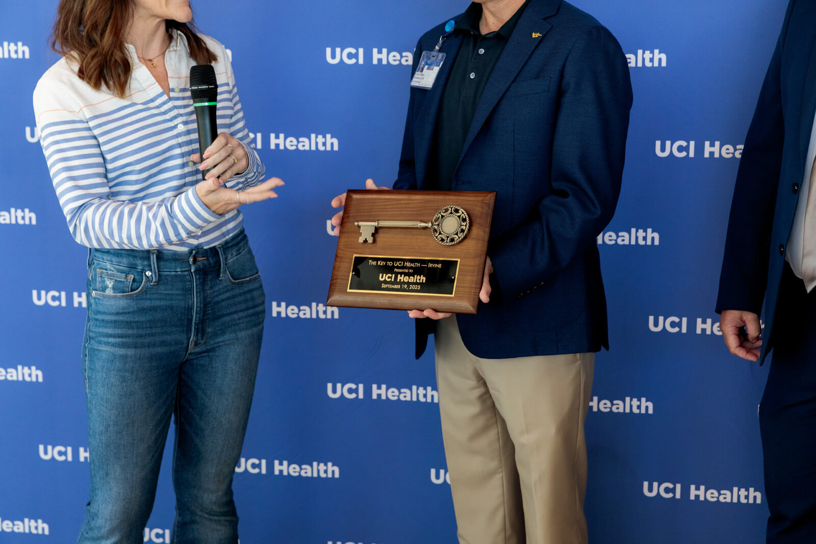 uci health president and ceo chad t lefteris receives a ceremonial key to uci health irvine from hensel phelps leaders in front of the uci health step and repeat at the uci health irvine substantial completion event on sept 19 2025