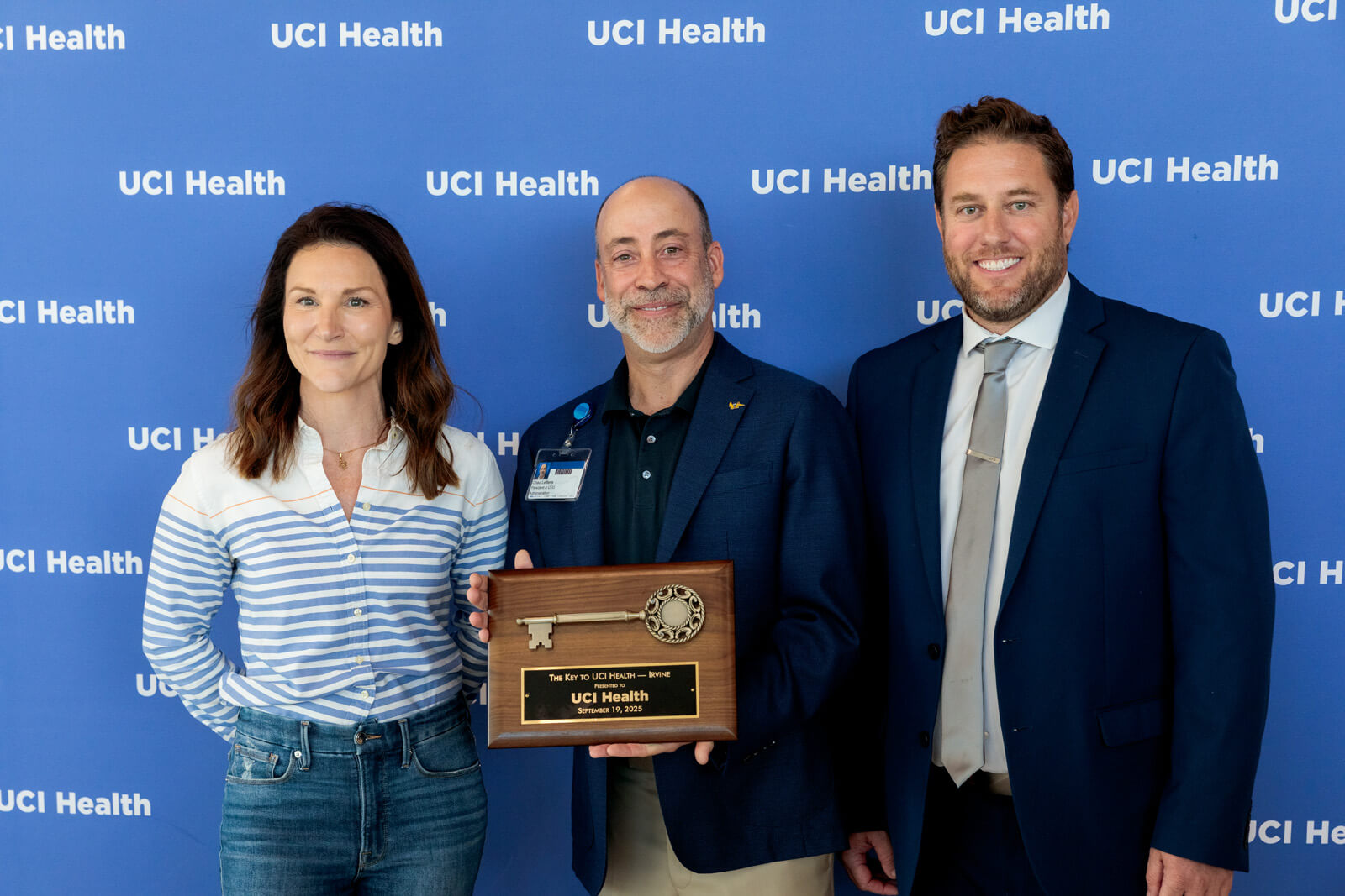uci health president and ceo chad t lefteris receives a ceremonial key to uci health irvine from hensel phelps leaders in front of the uci health step and repeat at the uci health irvine substantial completion event on sept 19 2025