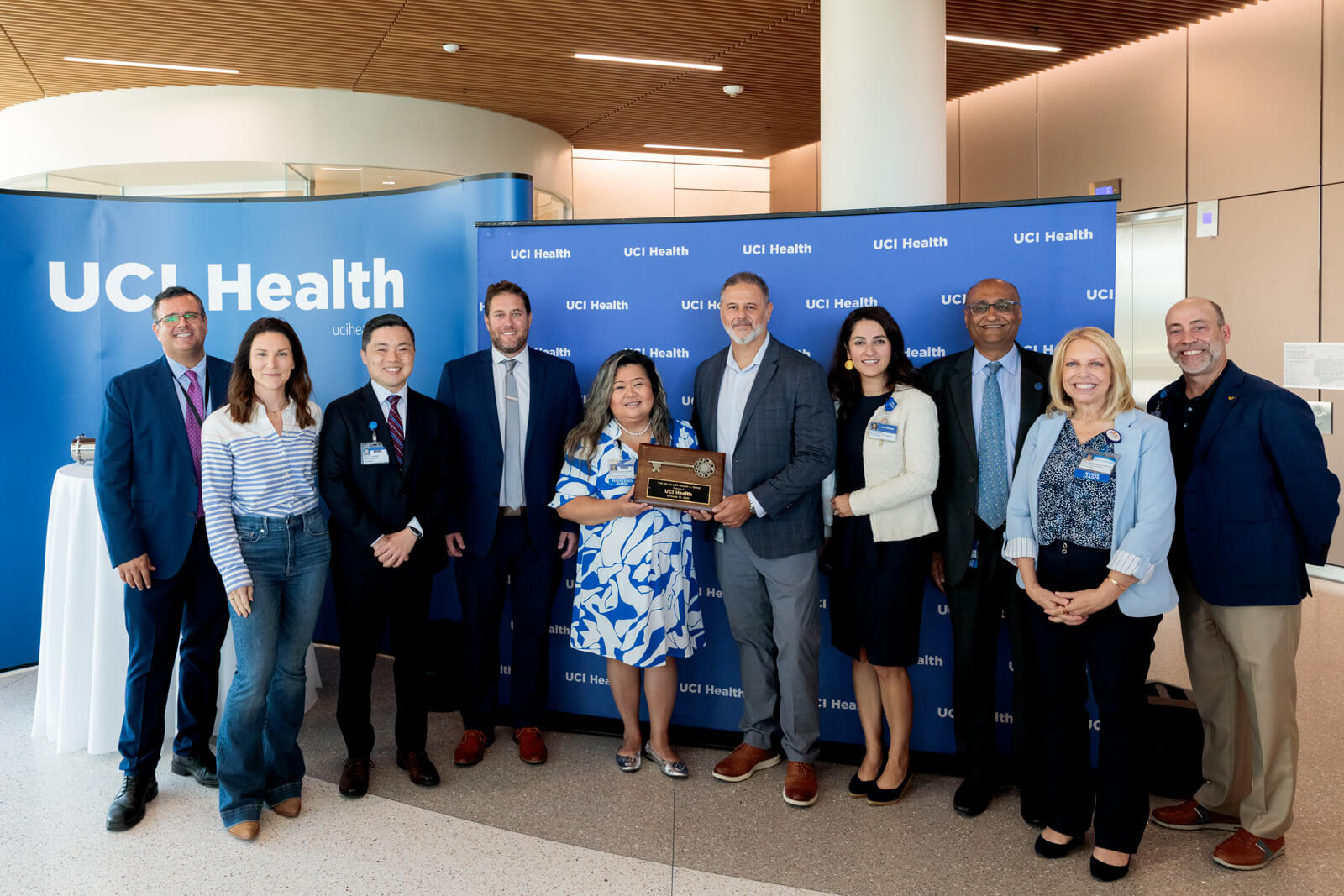 uci health and hensel phelps leaders pose for a photo in front of a uci health step and repeat at the uci health irvine substantial completion event on sept 19 2025