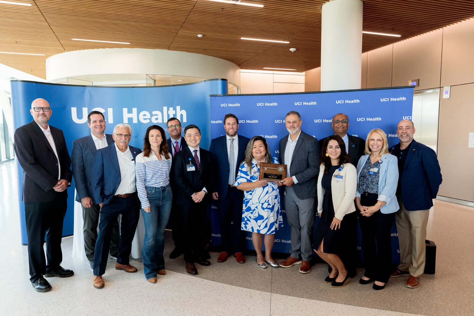 uci health and hensel phelps leaders pose for a photo in front of a uci health step and repeat at the uci health irvine substantial completion event on sept 19 2025