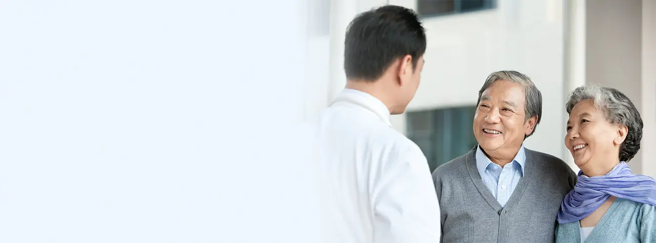 Happy elderly couple speaking to clinician