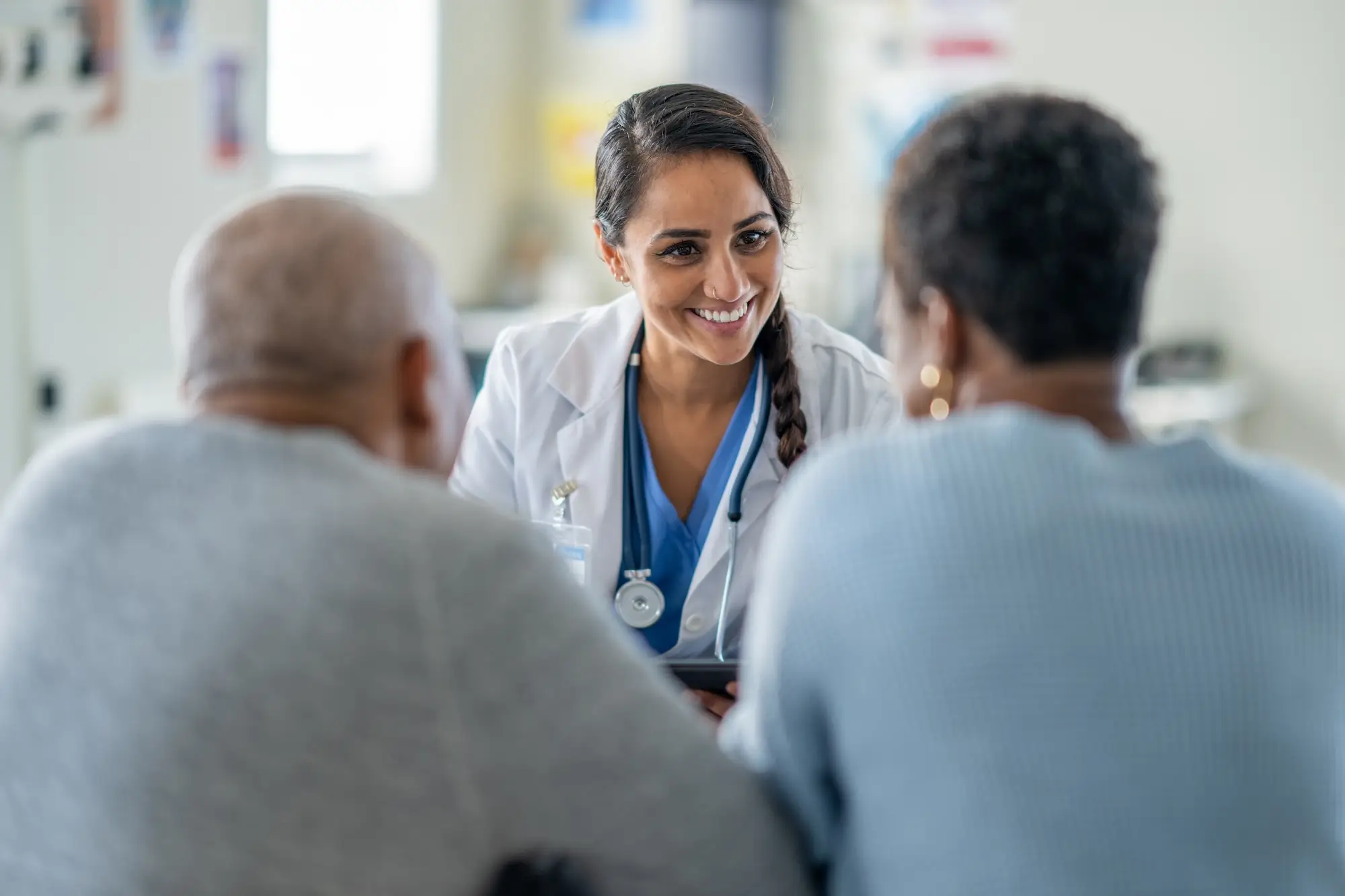 Friendly female doctor talks with couple