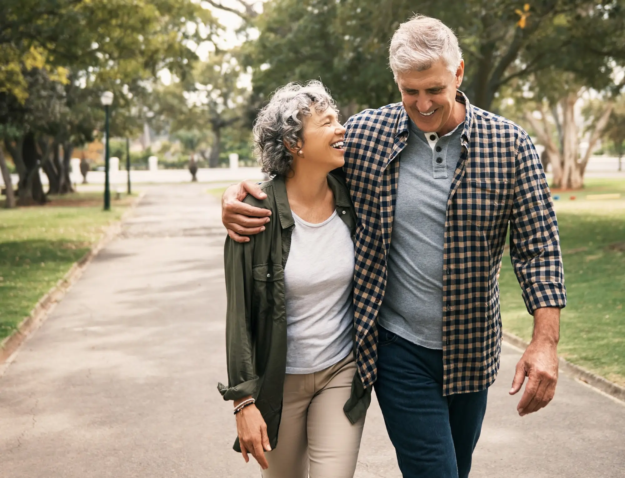 Mature smiling couple walks in a park