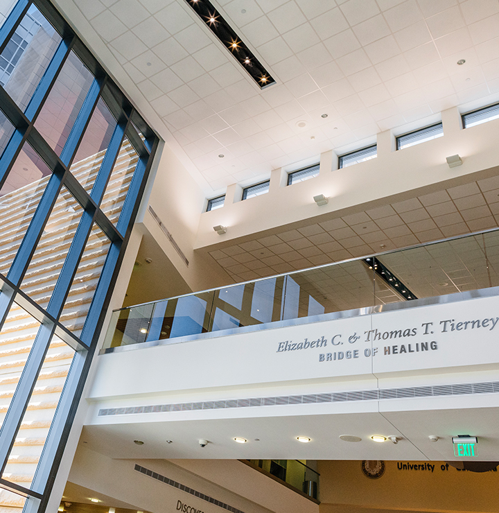 Interior of a modern building with large windows and a balcony. Sign reads "Elizabeth C. & Thomas T. Tierney Bridge of Healing.