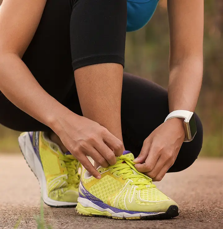 a women ties her shoe before going for a run