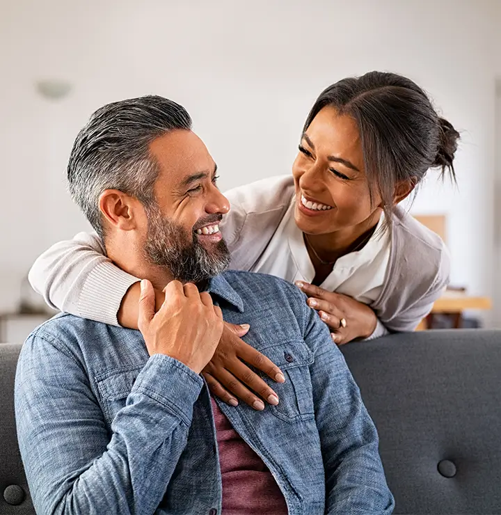 a man and a women smile at each other while in a friendly embrace