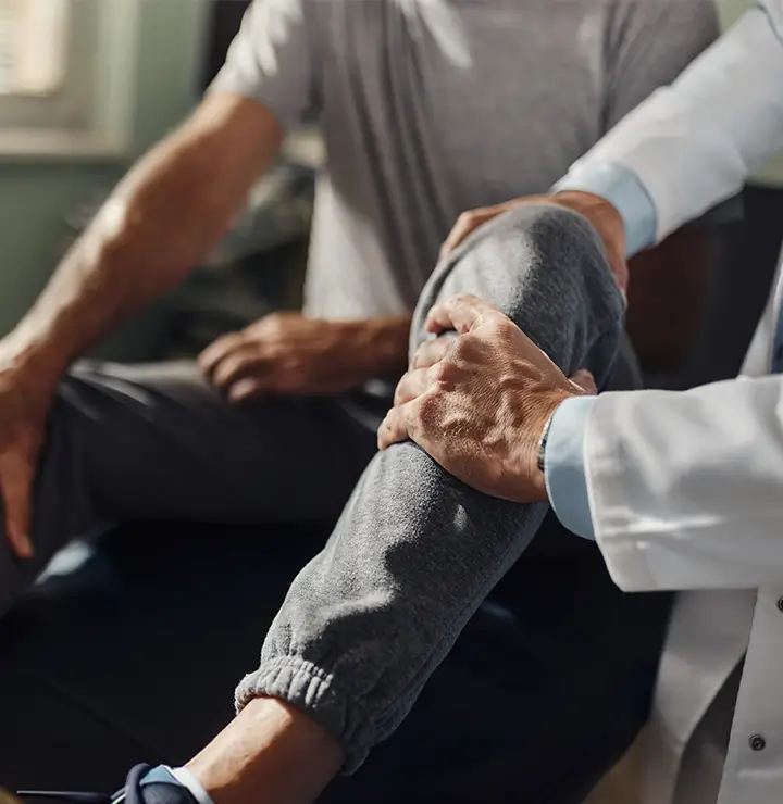 a doctor examines a patient who appears to be having knee pain