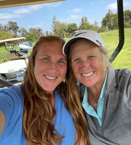 UCI Health nurses Amy Dobson and Sarah Martinez sitting together smiling on a golf cart.
